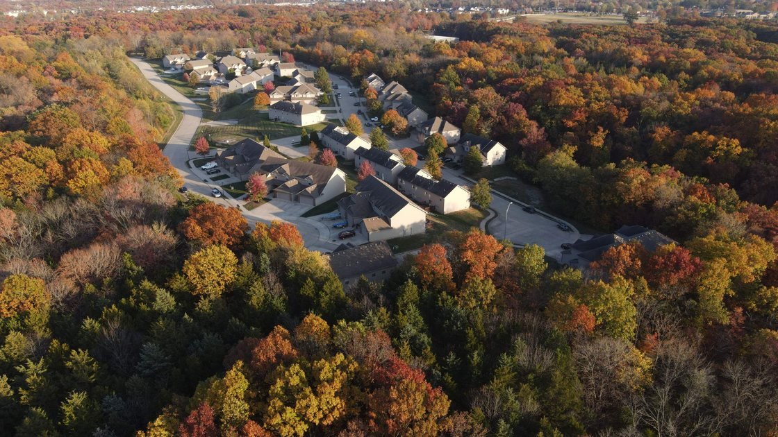 Aerial view of a neighborhood surrounded by fall trees